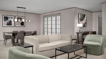 Una sala moderna con sofá, sillones, una mesa de centro, un comedor con sillas y un ventanal con persianas.