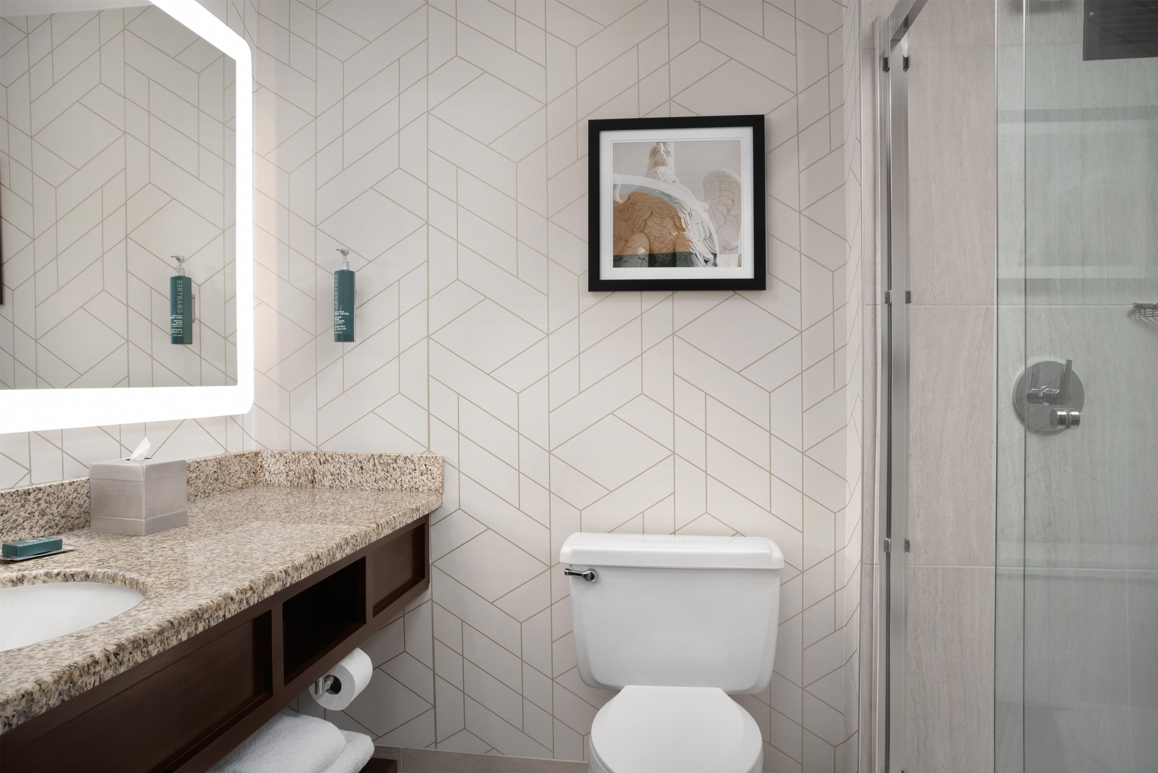 A bathroom with a toilet, sink, and shower.