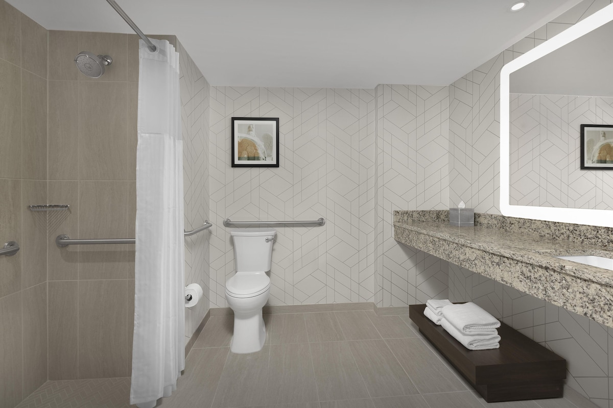 A modern bathroom with a shower, toilet, and vanity.