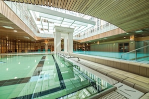 A large indoor swimming pool with a high ceiling and modern architecture.