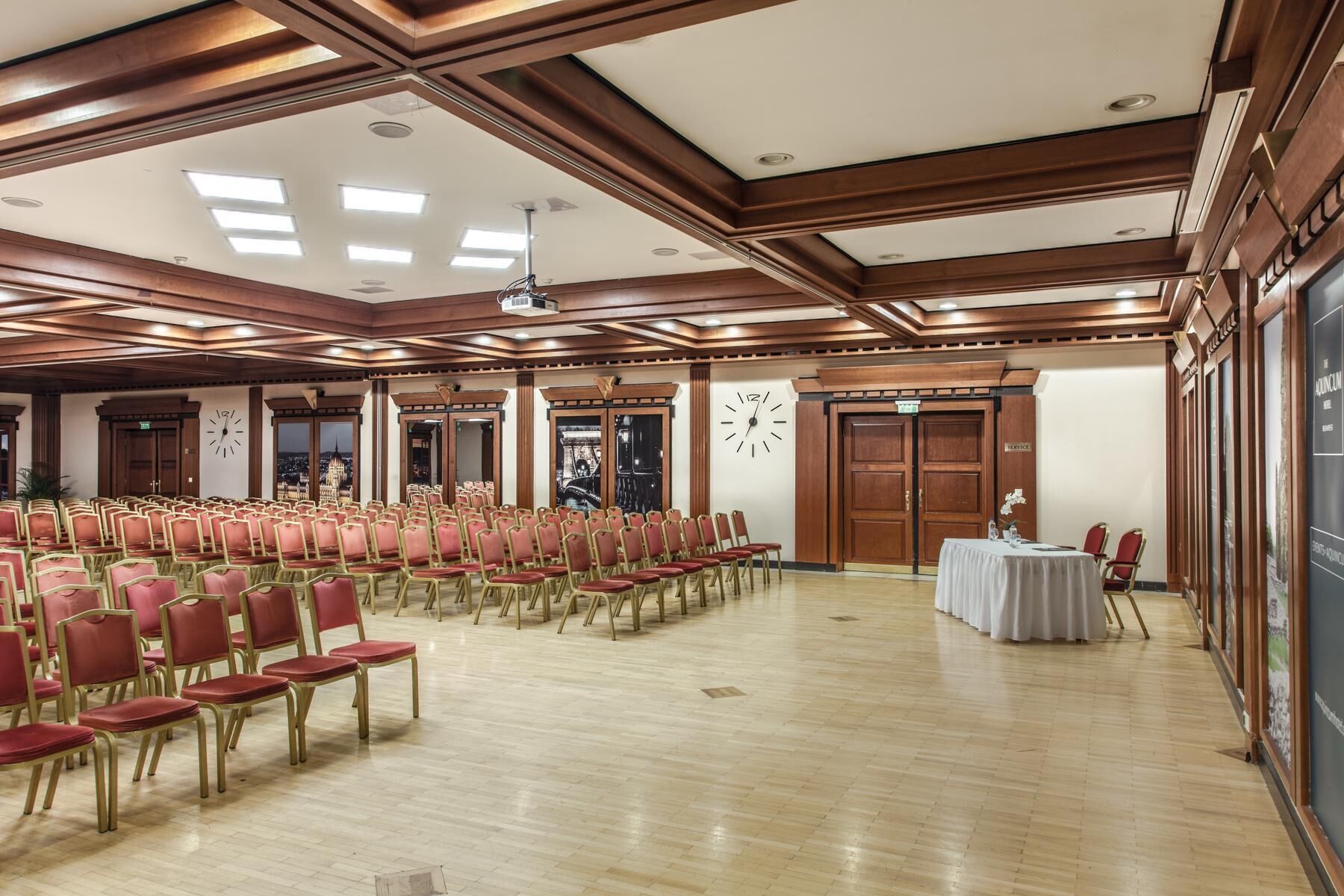 Une salle de conférence avec des rangées de chaises, une horloge et un comptoir de service.