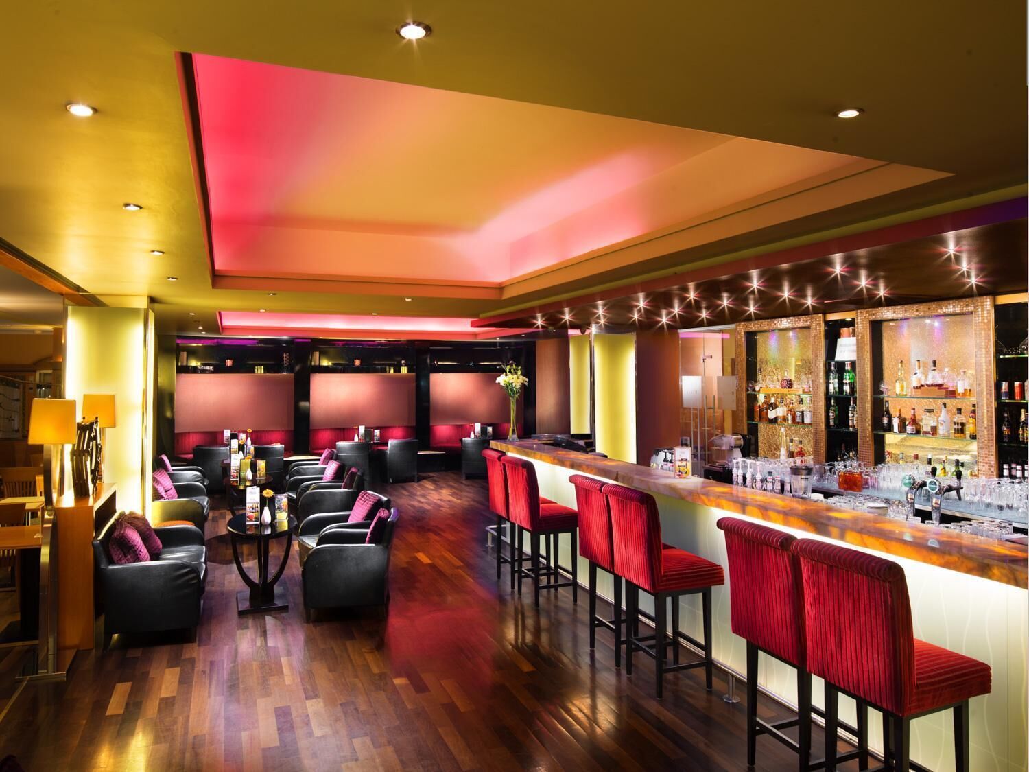 A bar area with seating, a bar counter, and a well-lit interior.