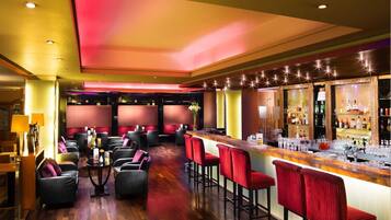 A bar area with seating, a bar counter, and a well-lit interior.