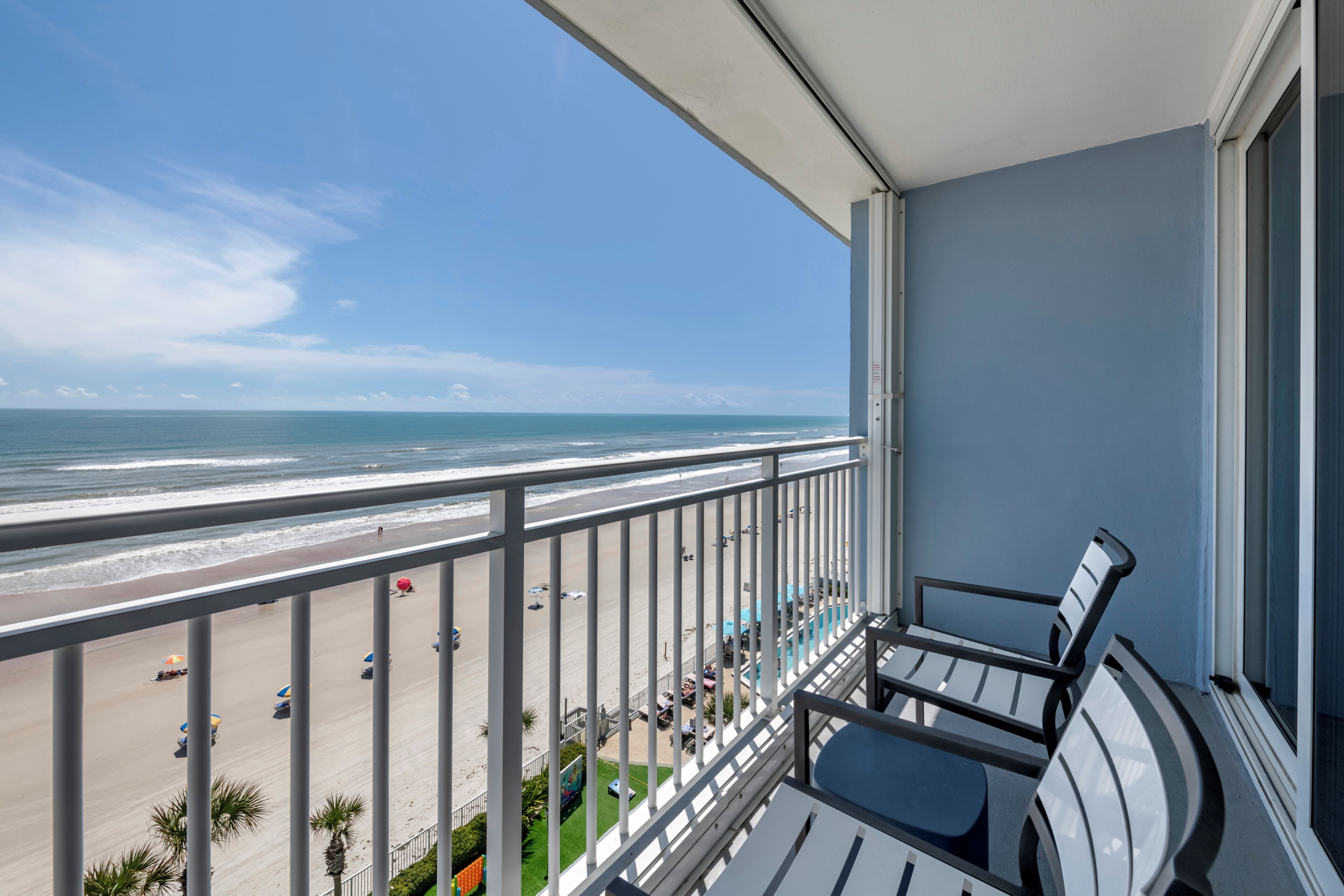 Ein Balkon mit Blick auf Strand und Meer.