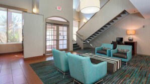 A spacious lobby with a staircase, seating area, and a large window. - Residence Inn by Marriott Bakersfield (Bakersfield)
