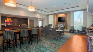A modern hotel lobby with a bar area, seating, and a large TV screen. - Residence Inn by Marriott Bakersfield (Bakersfield)