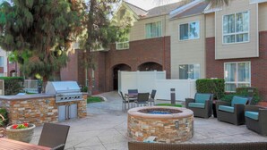 An outdoor patio with a grill, seating, and a fire pit. - Residence Inn by Marriott Bakersfield (Bakersfield)