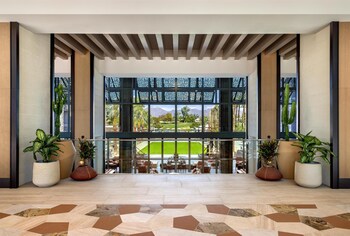 An outdoor dining area with tables and chairs, a fire pit, and string lights. at Grand Hyatt Scottsdale Resort