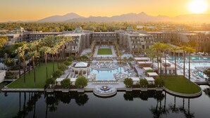 Ein Resort mit einem zentralen Pool, mehreren Gebäuden und Palmen.