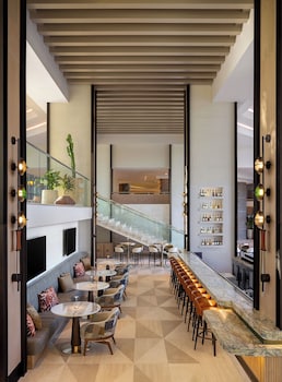 A building with a patio area, cacti, and palm trees. at Grand Hyatt Scottsdale Resort