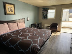 A bedroom with a bed, a desk, and a chair.