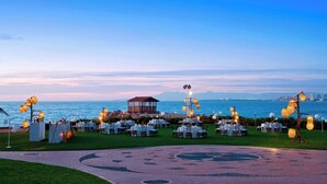 An outdoor wedding venue with round tables and chairs, a gazebo, and decorative lighting. - Sheraton Buganvilias Puerto Vallarta  (Puerto Vallarta)