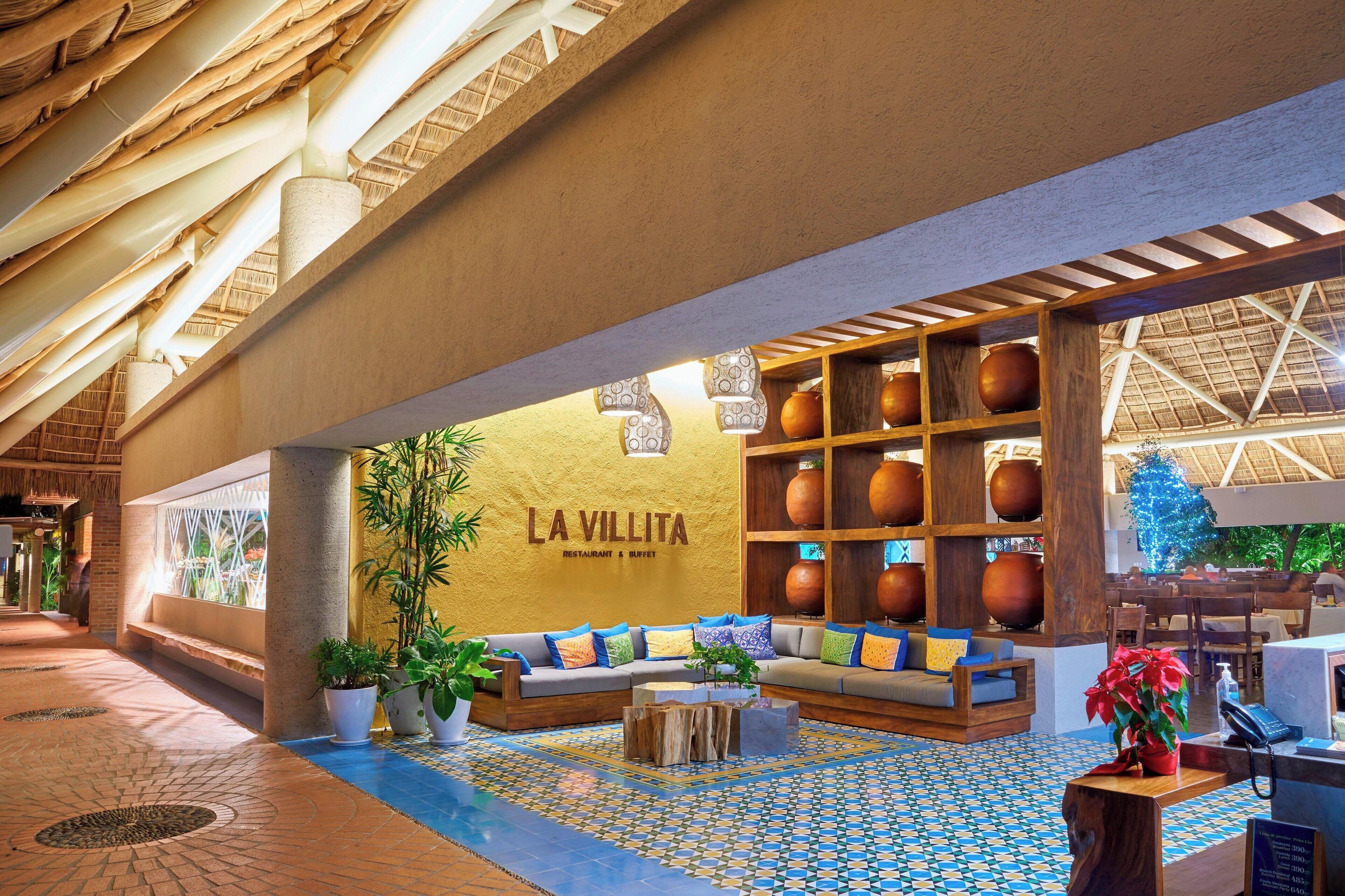 A spacious lobby with a seating area, a reception desk, and a wall with decorative vases.