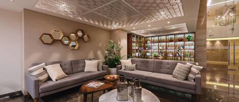 A modern lobby with two sofas, a coffee table, and decorative vases.