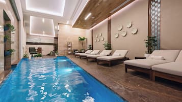 Relax by the long, rectangular pool surrounded by lounge chairs and decorative elements.
