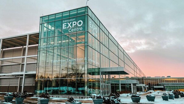 Een modern glazen gebouw met de aanduiding "Edmonton Expo Centre", met een grote glazen gevel en een plat dak.