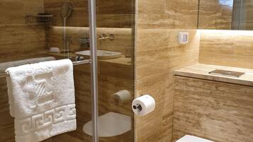 A modern bathroom with a glass shower enclosure, a toilet, and a sink.