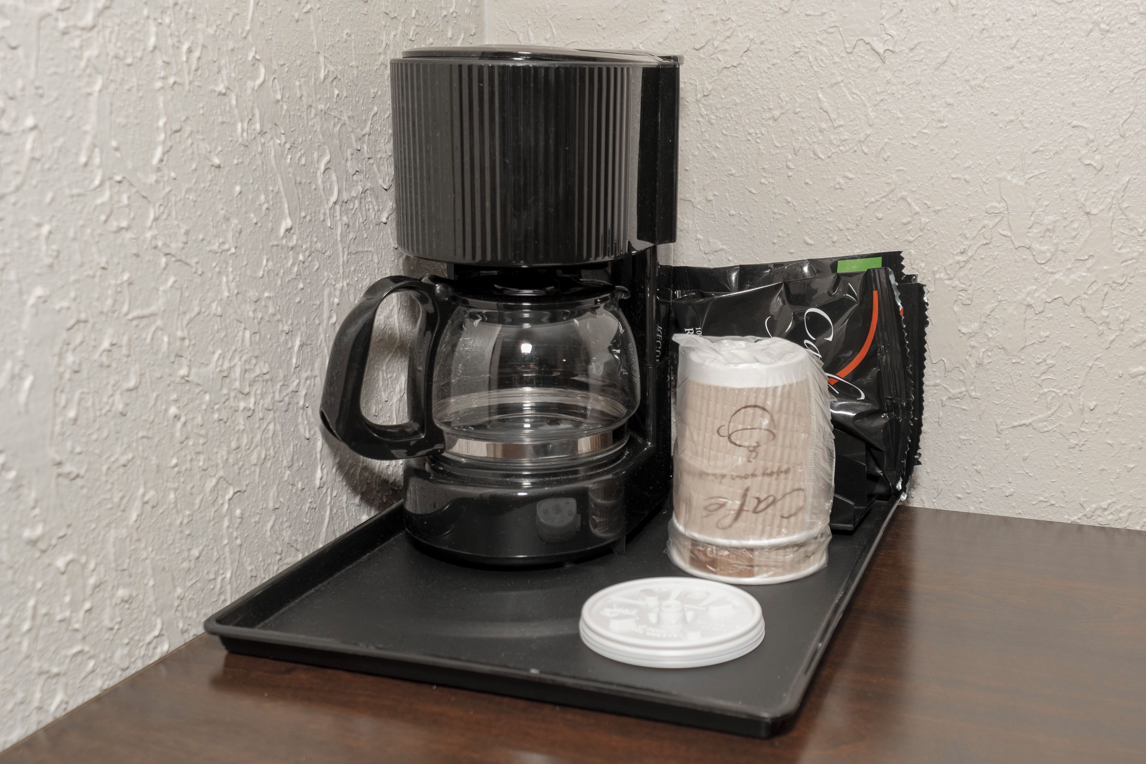 Una macchina da caffè su un vassoio, con una cialda e un coperchio.