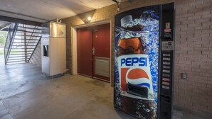 A vending machine with a Pepsi logo, a refrigerator, and a door labeled "LAVATORY".