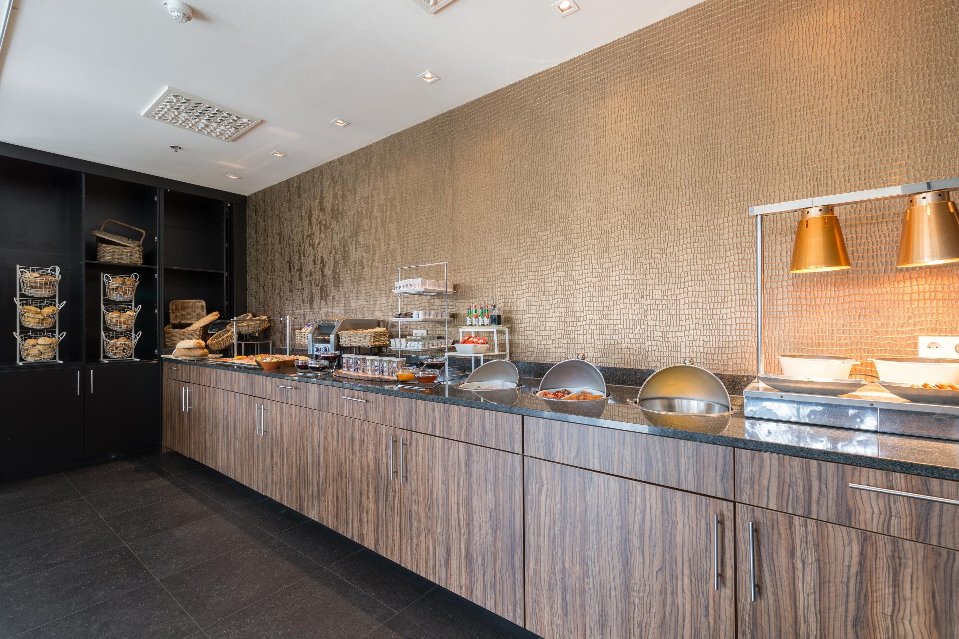 Una cocina moderna con armarios de madera, encimera de vidrio y pared con textura.