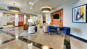 A spacious lobby with a polished floor, seating areas, and modern lighting fixtures. - Drury Inn & Suites Sikeston, MO (Sikeston)