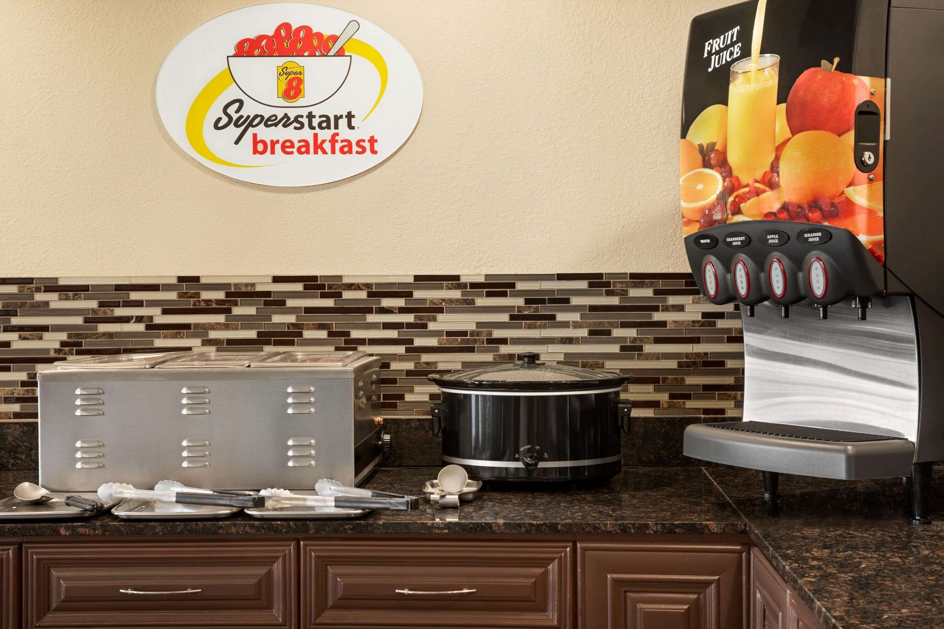 Une petite cuisine équipée d’un panneau indiquant un petit-déjeuner « Superstart », d’une machine à café, d’une mijoteuse et d’un grille-pain.