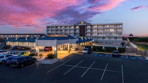A Comfort Inn hotel with a parking lot and a sunset sky.