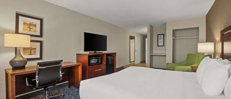 Une chambre d’hôtel équipée d’un lit, d’un bureau, d’une chaise, d’une télévision et d’un four à micro-ondes.