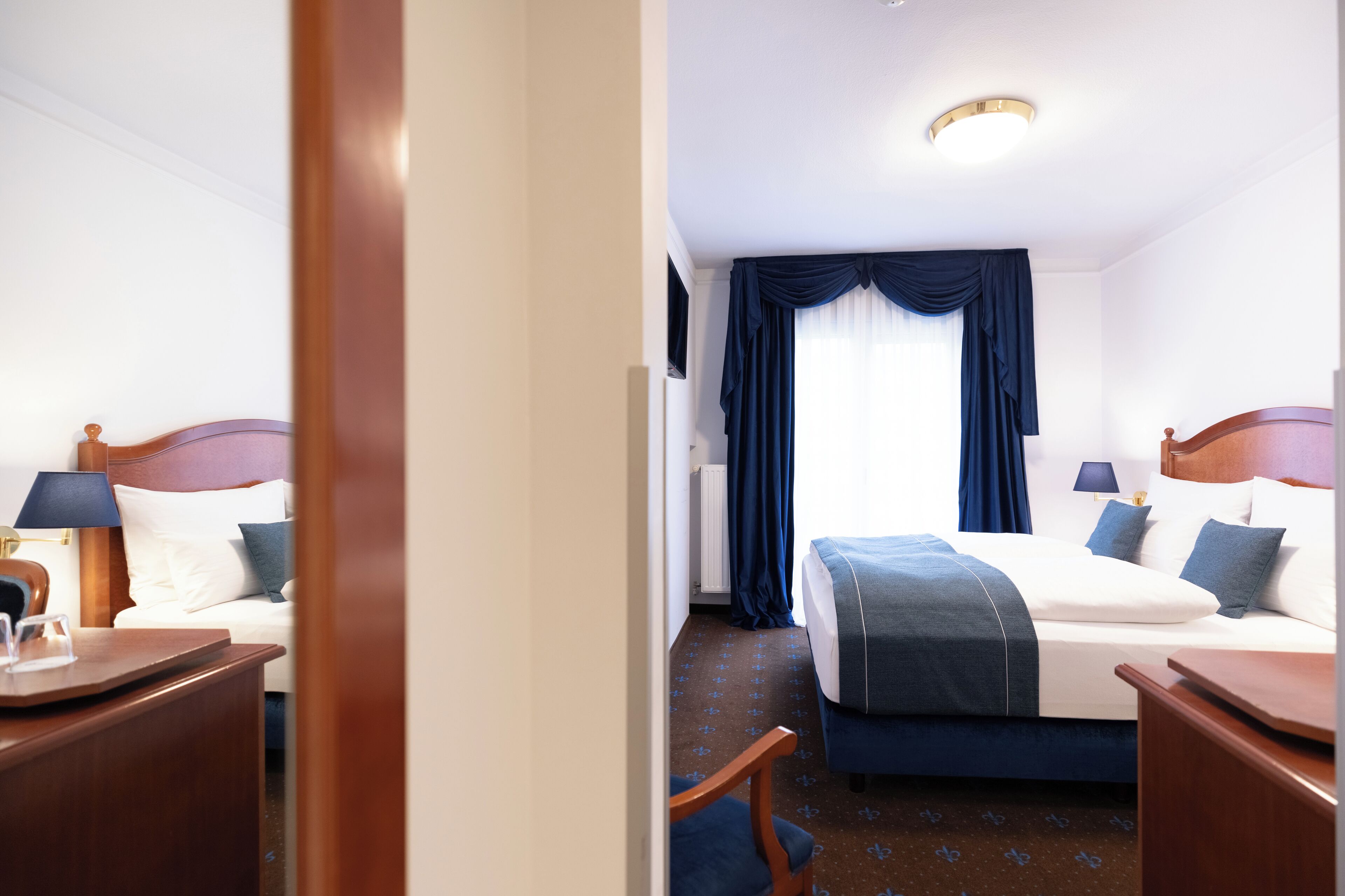 Ein Hotelzimmer mit Bett, Nachttischen, Lampen und einem Sessel.