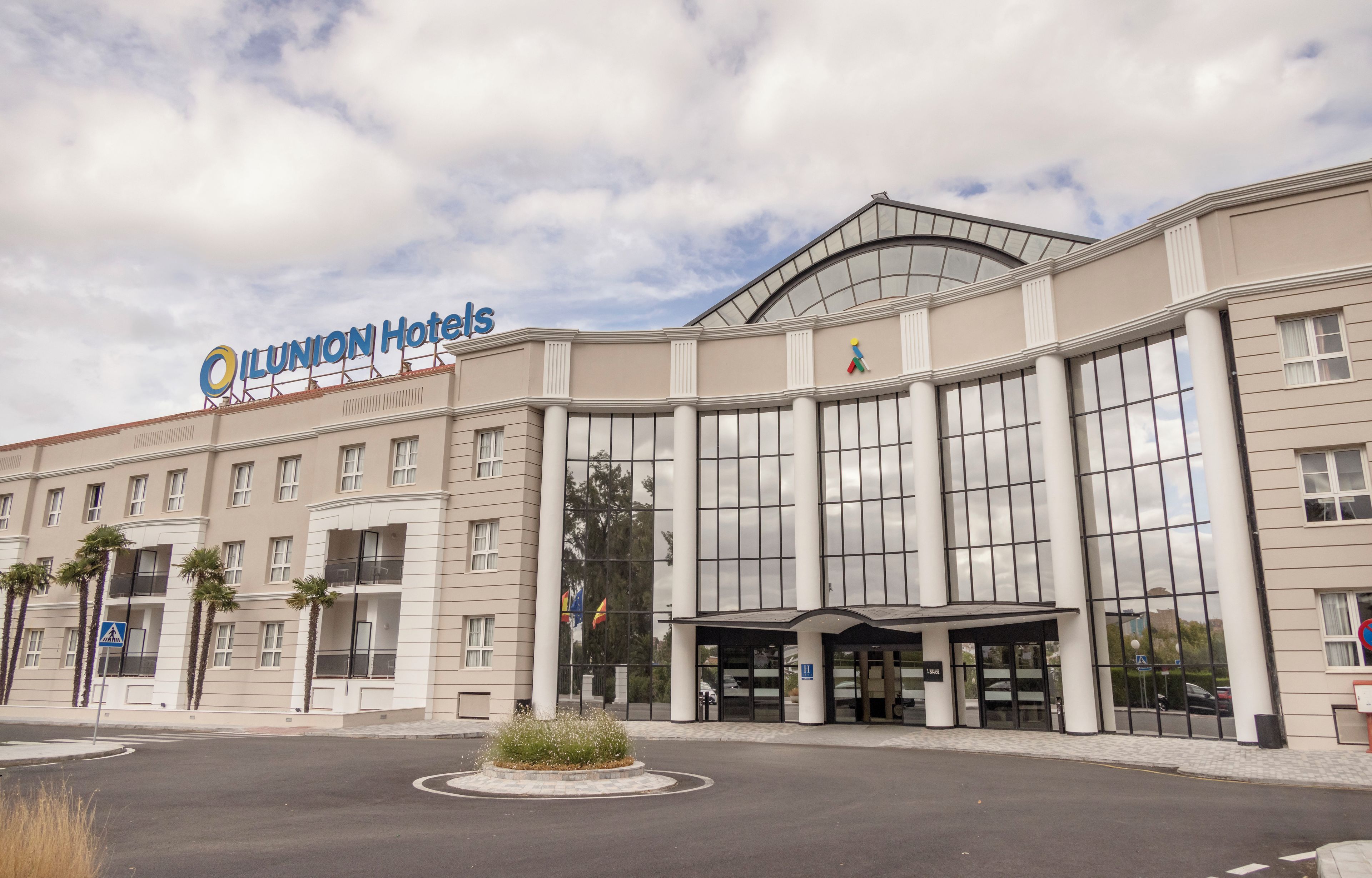 A hotel with a large entrance, multiple windows, and a sign reading 'ILUNION Hotels'.