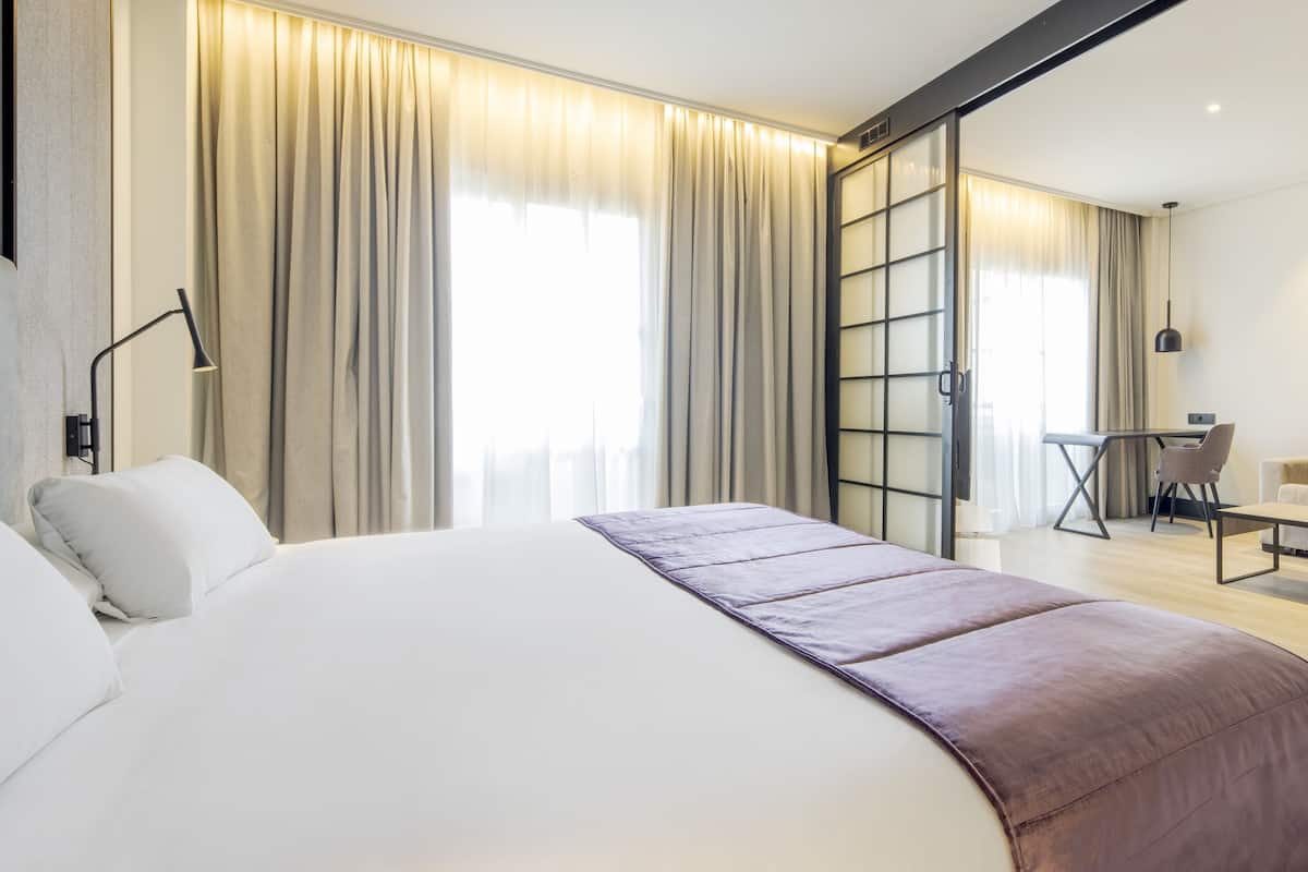 Een moderne hotelkamer met een groot bed, een bureau en een bank.