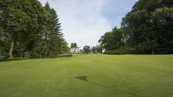 Enjoy a serene golfing experience amidst mature trees and a well-manicured green fairway.