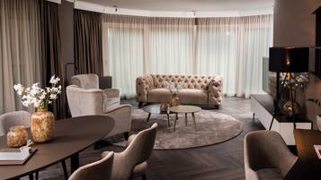 Un salon moderne avec un canapé capitonné, une table basse ronde et un coin repas comprenant une table et des chaises.