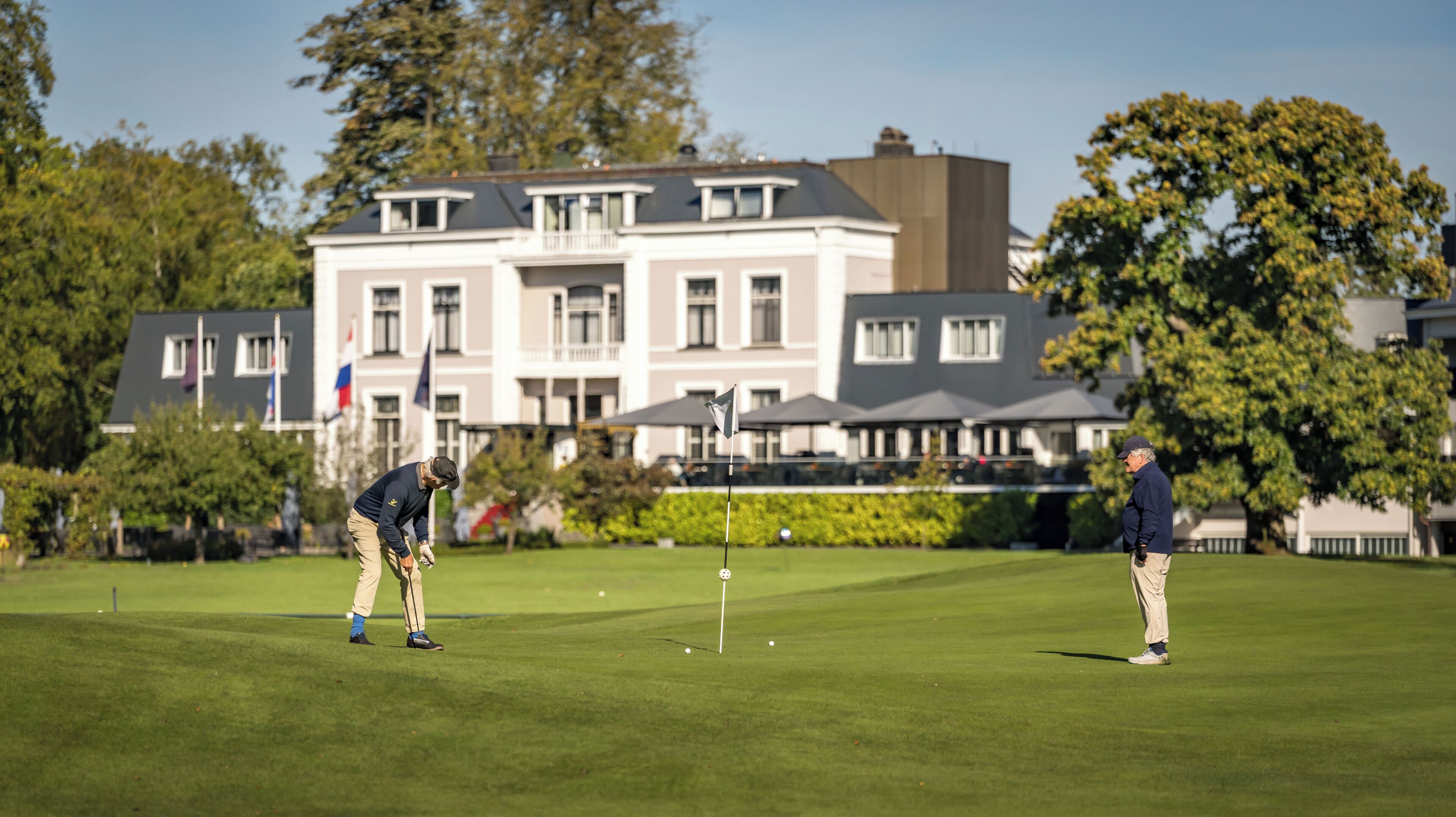 Un campo de golf con un edificio al fondo.
