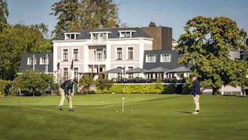 Un campo de golf con un edificio al fondo.