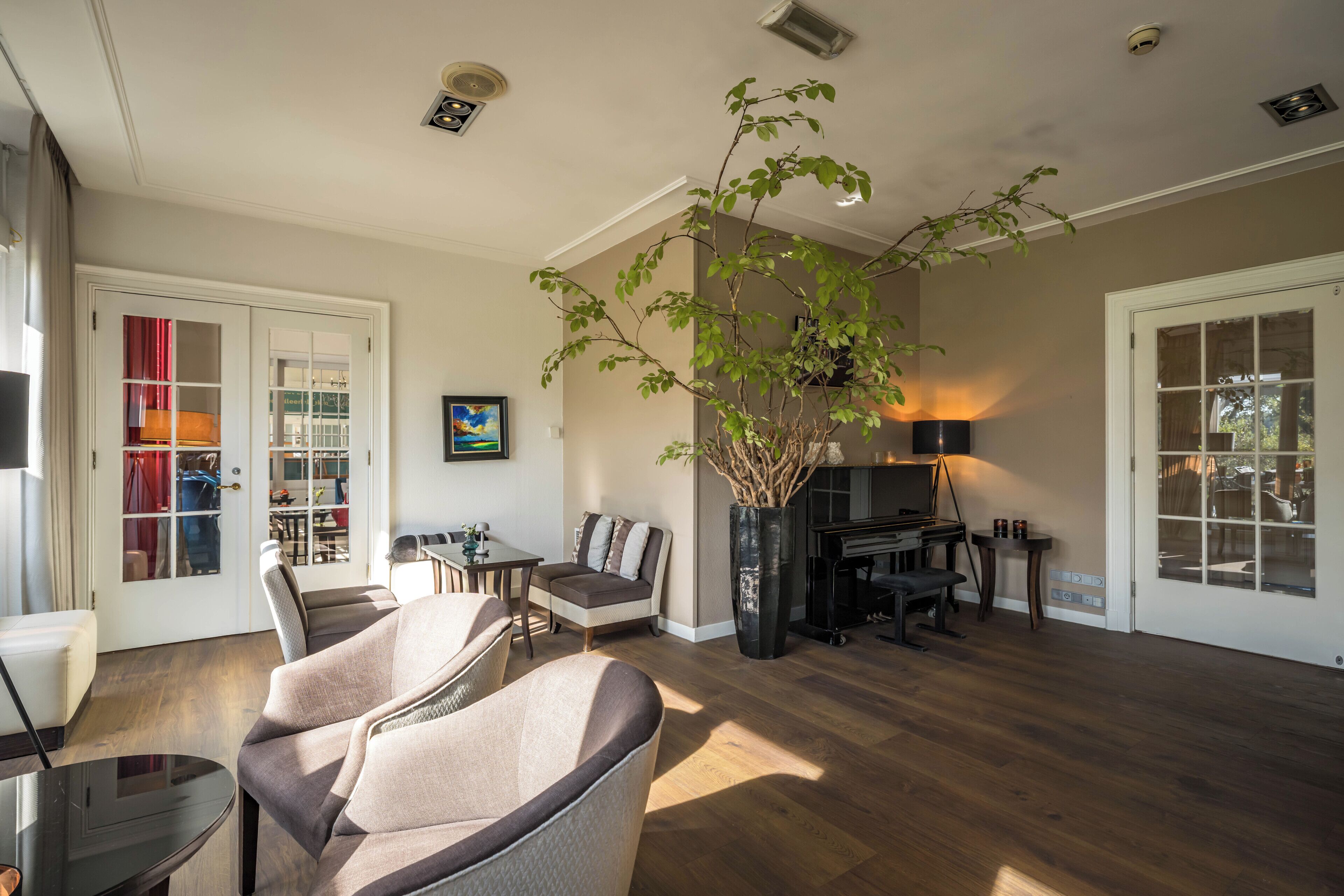 A living room with a fireplace, a dining area, and a large potted plant.