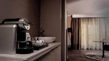 Habitación de hotel moderna con una cafetera, un cuenco y vasos sobre la encimera.