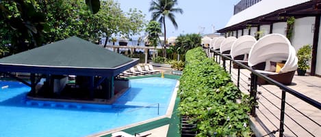 Una piscina al aire libre, tumbonas