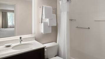 Une salle de bain moderne équipée d’un lavabo, de toilettes et d’une douche.