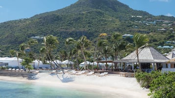 En privat strand, parasoller, badehåndklæder, snorkling