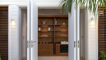 Enter a compact, open-plan space with a kitchen area featuring a central island and wooden cabinetry.