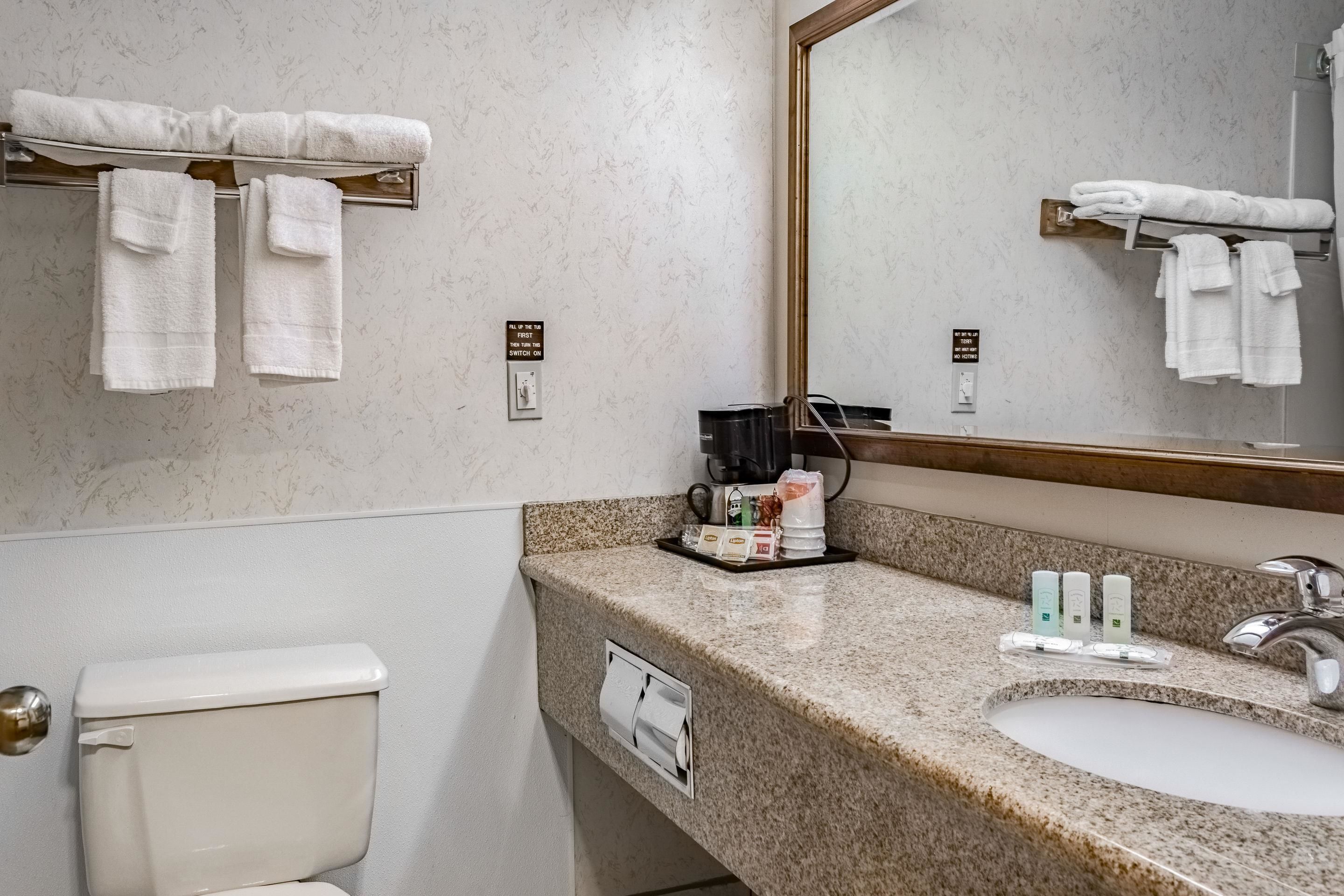 Une salle de bain équipée de toilettes, d’un lavabo et d’un porte-serviettes.