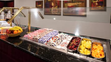 A buffet with various food items including fruits, dairy products, and desserts.