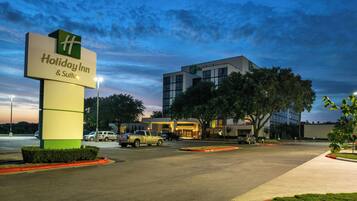 A Holiday Inn & Suites with a modern building and a parking lot.