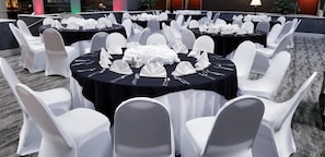 A banquet hall with round tables set with white tablecloths, silverware, and folded napkins. - Holiday Inn Hotel & Suites Beaumont Plaza (I-10 & Walden) by IHG (Beaumont)