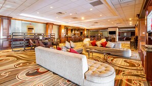 A spacious lobby with a large seating area, a reception desk, and a bar. - Wyndham Omaha / West Dodge (Omaha)