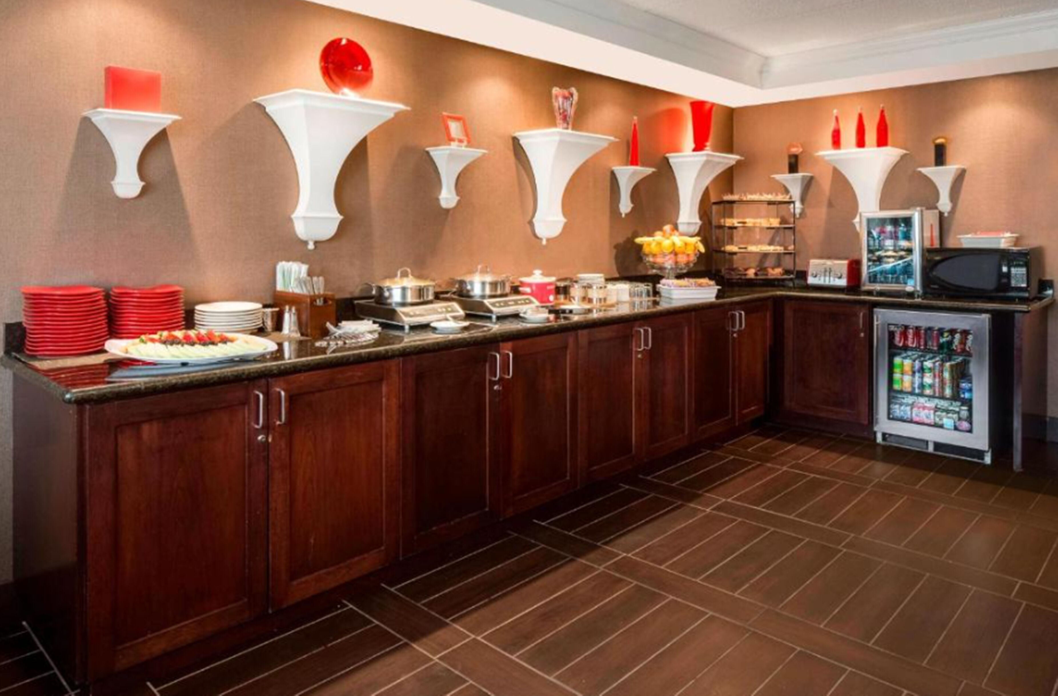 A kitchen with wooden cabinets, a countertop with food items, and a refrigerator.
