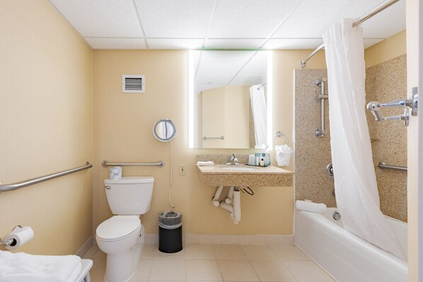 A bathroom with a toilet, sink, bathtub, and shower curtain.