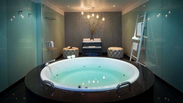A modern bathroom with a large oval bathtub, a glass shower enclosure, and a wall-mounted towel rack. - The Como Melbourne by Accor (South Yarra)