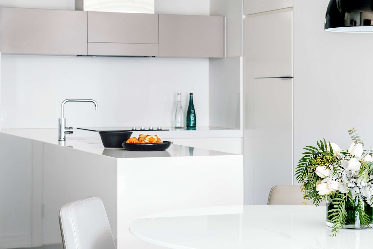 A modern kitchen with a central island, a built-in stove, and a sleek faucet.